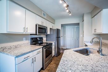 Upgraded Apartment kitchen with granite countertops and stainless steel appliances.